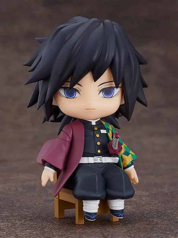 The Good Smile Company Demon Slayer: Kimetsu no Yaiba – Giyu Tomioka Nendoroid Swacchao! features a chibi Giyu in uniform and colorful haori, seated on a chair with spiky black hair, blue eyes, and his mini sword at the waist.