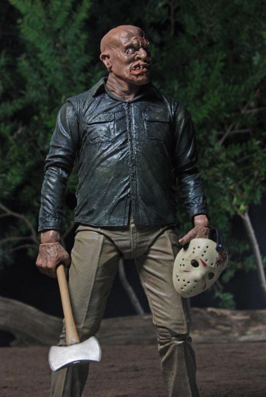 The NECA Friday the 13th Part IV: The Final Chapter Jason Voorhees Ultimate 7-inch Action Figure stands outdoors at night with an axe and hockey mask, dressed in dark shirt and tan pants—ideal for collectors and horror fans.