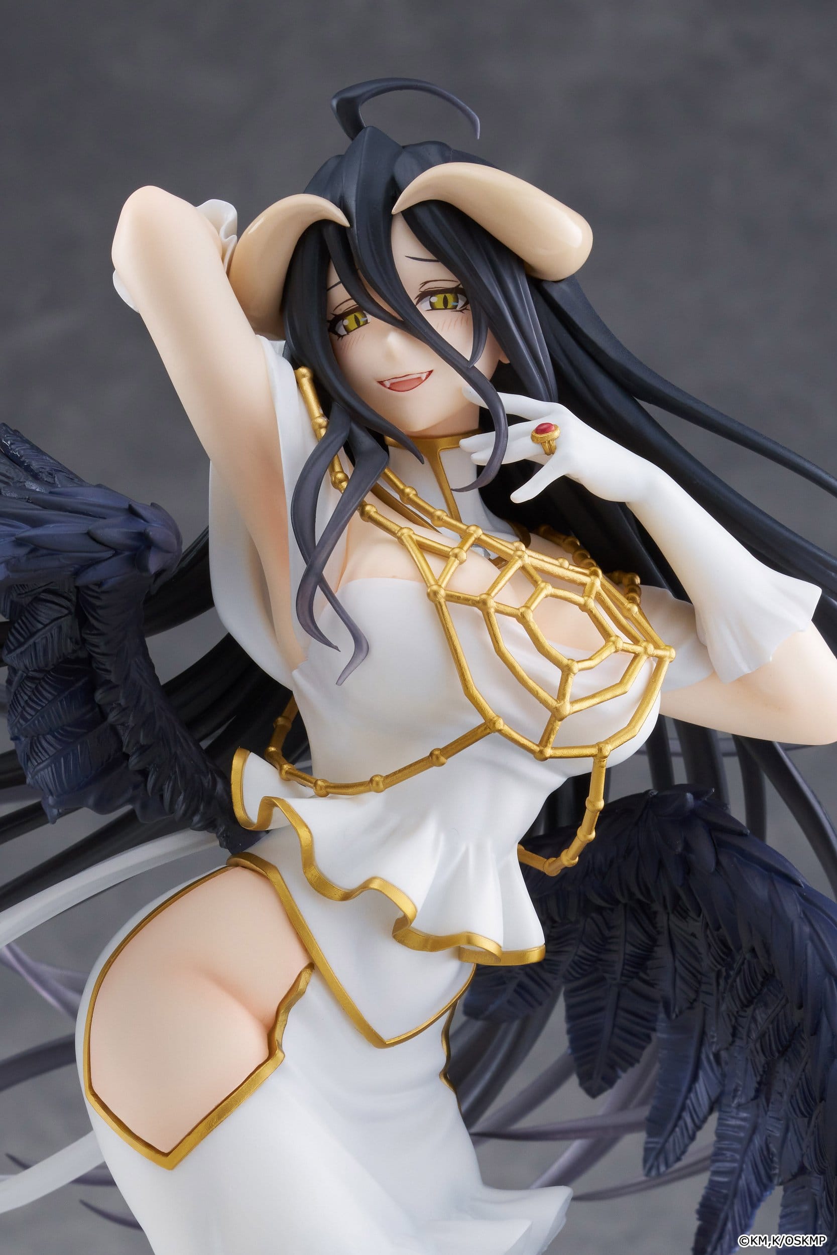The Taito Overlord T-most Albedo Pure White Devil Version PVC Statue (29 cm) features Albedo, a dark-haired woman with horns, yellow eyes, and black wings in an elegant white and gold dress, gracefully posed with one arm raised.