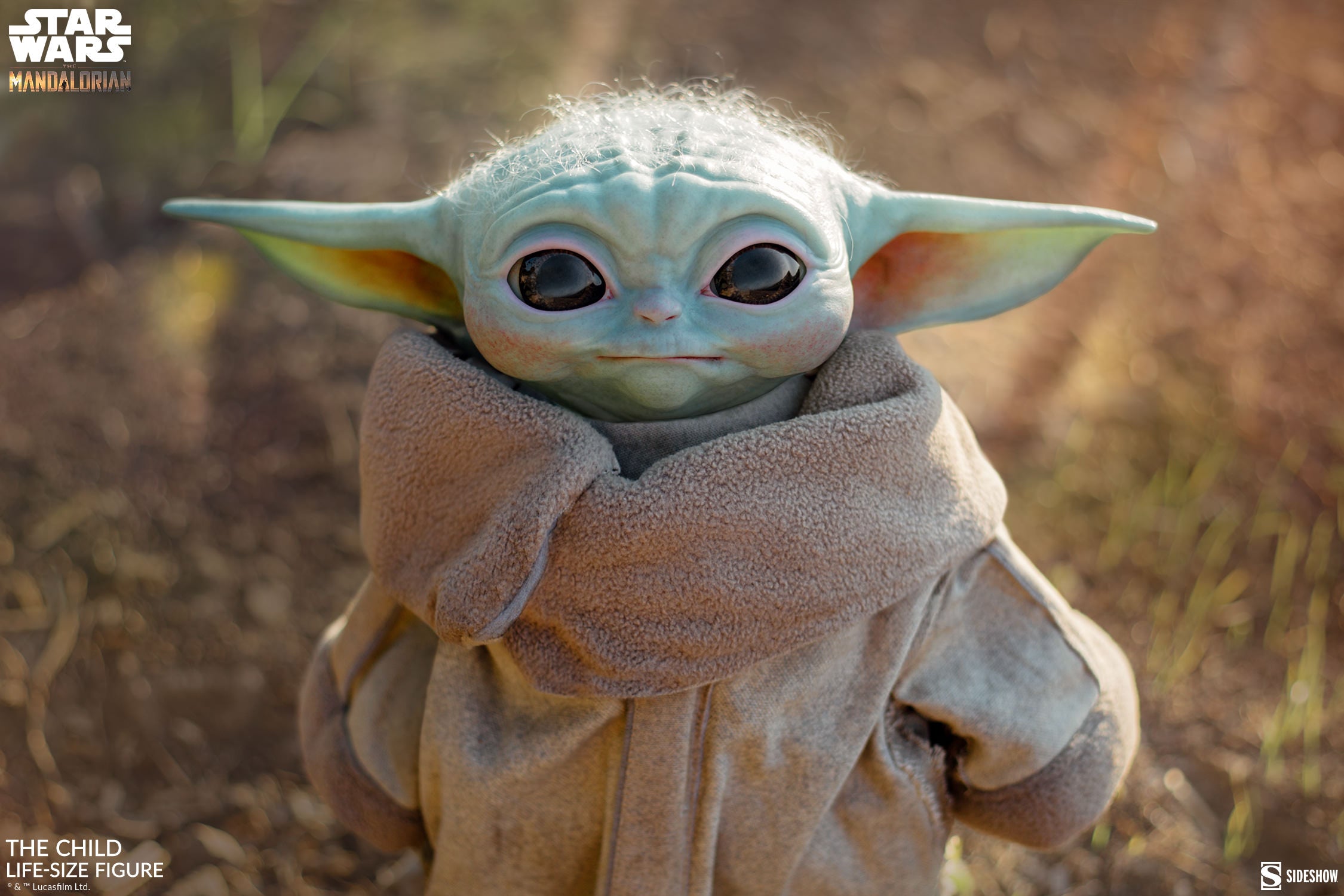 Sideshow’s Star Wars: The Mandalorian – The Child Life-Size Figure (1:1 Scale) features Grogu in a tan robe with big eyes and long ears, gazing up adorably—a perfect collectible for fans.